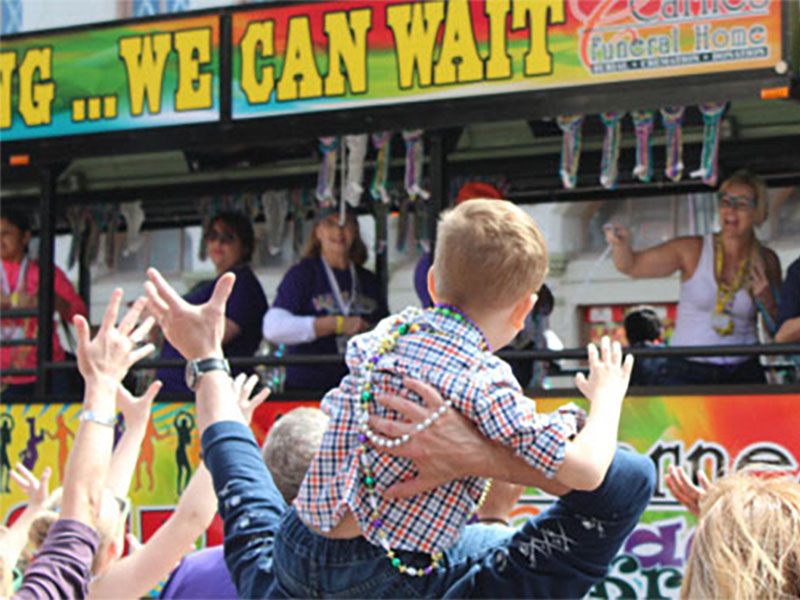 Kid on Shoulders Catching Beads